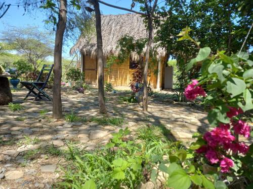 a house with a bunch of flowers in front of it at Wasi Center Homestay in Máncora