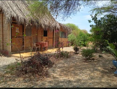 a small hut with a table in front of it at Wasi Center Homestay in Máncora
