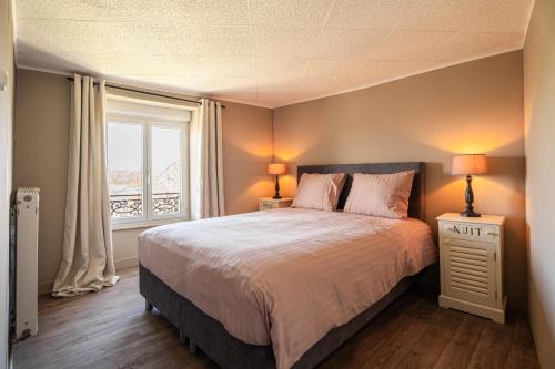 una camera da letto con un letto grande e una finestra di La Maison de la Liberte a Laferté-sur-Amance