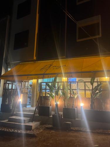 a building with a yellow wing at night at Playa Surf House in Tamraght Ouzdar