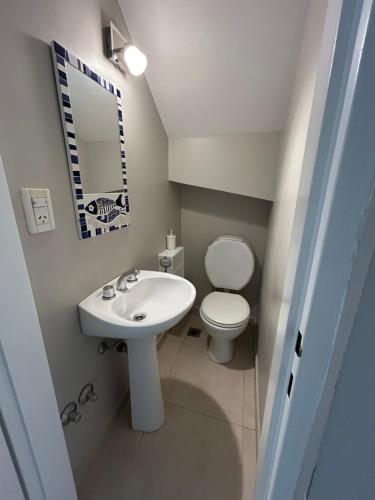 een badkamer met een wit toilet en een wastafel bij Refugio Sur in Puerto Madryn