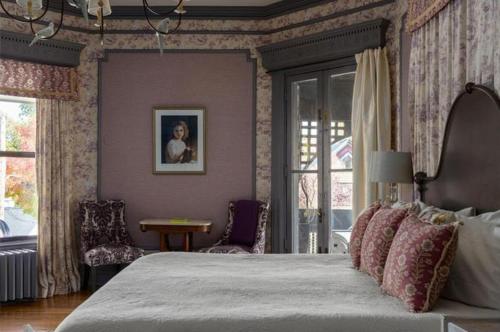 a bedroom with a large bed and a table and chairs at The New Victorian Mansion Bed & Breakfast in Saint Paul