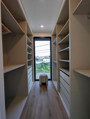 a walk in closet with a window and shelves at Caparica Sun & Serenity in Charneca