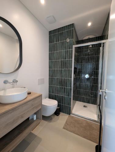a bathroom with a shower and a sink and a toilet at Caparica Sun & Serenity in Charneca