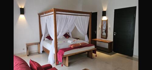 Un dormitorio con una cama con dosel en Pool villa not overlooked, en Montongbuwoh