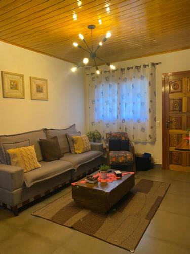 a living room with a couch and a table at Casa Aconchegante na Montanha in Campos do Jordão