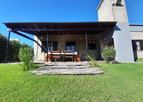 a patio with a wooden table in front of a house at La casita de Todd in Todd