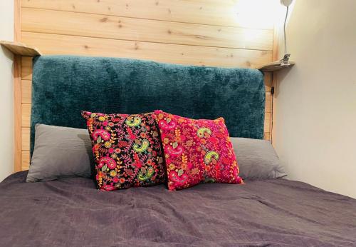 a bed with two pillows and a green headboard at The Groves at Redway Beach - Studio in Redway