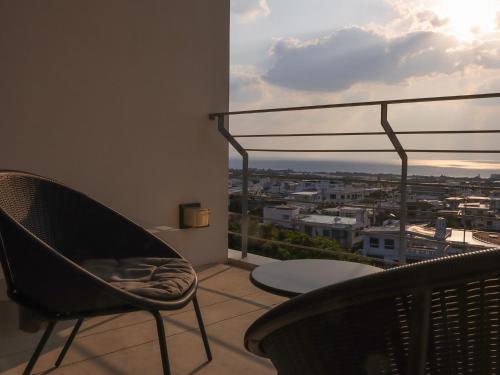 a balcony with a chair and a view of a city at 真常寺読谷サロン in Yomitan