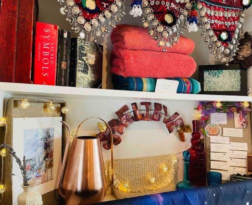 a shelf with books and a lamp on a desk at The Groves at Redway Beach - Studio in Redway