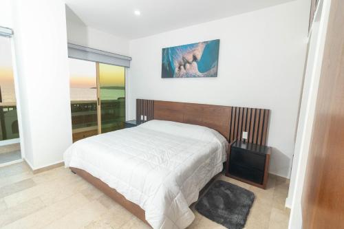 a bedroom with a bed and a large window at Vista al mar en Bucerías in Bucerías