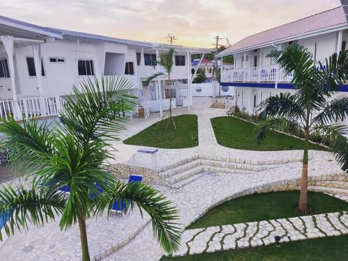 a courtyard of a hotel with palm trees and buildings at Begona Cliff Hotel in Negril