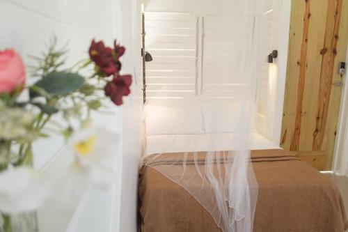 a bedroom with a bed with a door and a vase of flowers at Begona Cliff Hotel in Negril