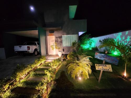 a house with a sign in the yard at night at Casa Bela Vista in Japaratinga
