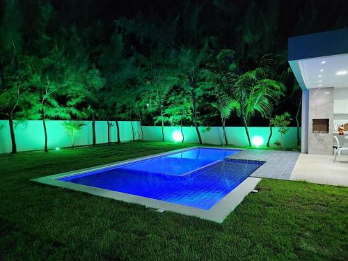 a swimming pool in a yard at night at Casa Bela Vista in Japaratinga