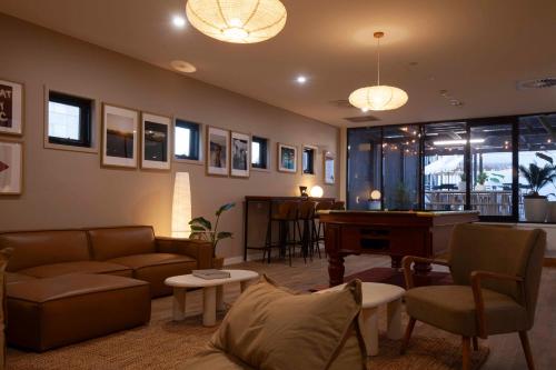 a living room with a couch and a piano at Little Drifter Canberra in Canberra