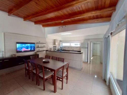 a kitchen and dining room with a table and chairs at Casa con Pileta y Jardin Zona Termas Concordia in Villa Zorraquín