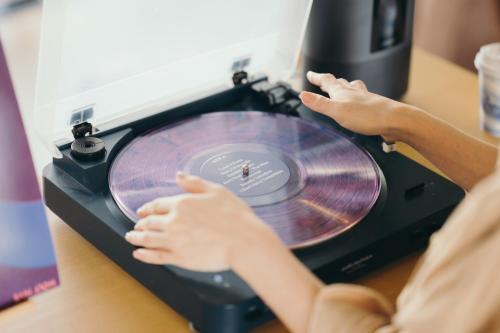 a woman sitting at a table with a record player at Setre Marina Biwako in Moriyama