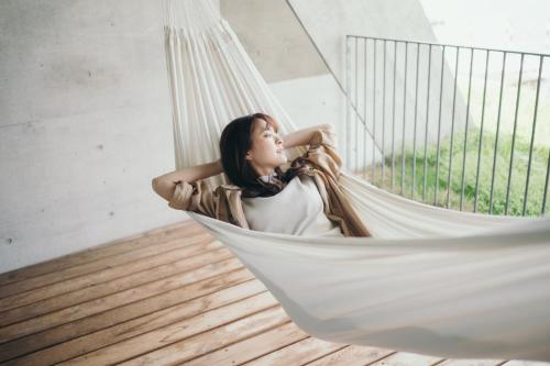 a woman is sitting in a hammock at Setre Marina Biwako in Moriyama