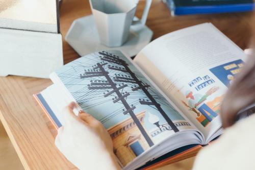 a person reading a book on a desk at Setre Marina Biwako in Moriyama