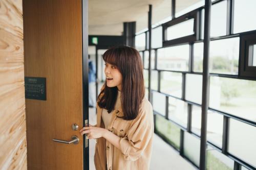 a woman opening a door in a building at Setre Marina Biwako in Moriyama