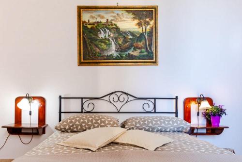 a bedroom with a bed and a painting on the wall at L'Orologio in Tivoli