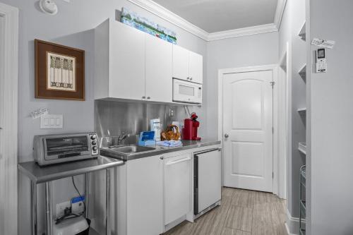 a white kitchen with a sink and a microwave at Bridgeview on Broad home in Beaufort