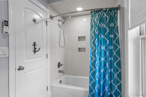 a bathroom with a shower with a blue shower curtain at Bridgeview on Broad home in Beaufort