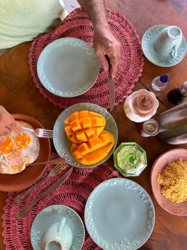 einen Tisch mit Teller mit Speisen darüber in der Unterkunft Casa Ingapura Suite Tainha - Povoado Bar da Hora 15 min de canoa para Atins - Estilo B&B - Café da Manhã Simples - Conforto in Atins