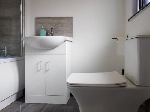 Un baño blanco con inodoro y lavabo. en Chatham lodge Cosy Large Double Room 1, en Stoke on Trent