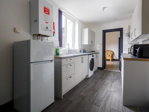 a kitchen with a refrigerator and a washer and dryer at Chatham lodge Cosy Large Double Room 1 in Stoke on Trent