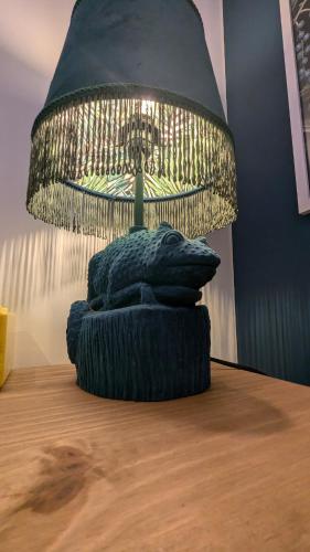 a lamp sitting on top of a table with a pillow at Stylish Condo on Victorian Seafront, Voyagers Rest Bexhill in Bexhill