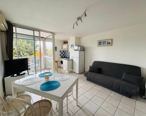 un salon avec une table et un canapé dans l'établissement Au cœur du Cap, au Cap d'Agde