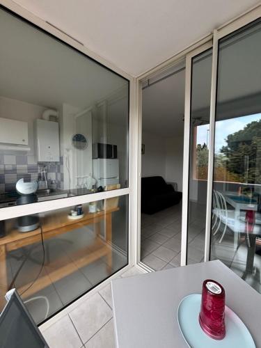 une cuisine avec des portes coulissantes en verre et une table dans l'établissement Au cœur du Cap, au Cap d'Agde