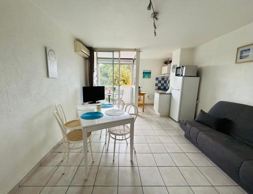 un salon avec une table et un canapé dans l'établissement Au cœur du Cap, au Cap d'Agde