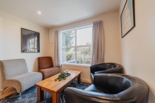 a living room with leather chairs and a table and a window at Moonbeam Nights - Kitchenette Parking Sleeps 3 in Lake Tekapo