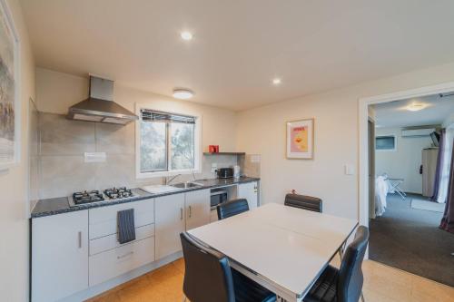 a kitchen with a table and chairs in a kitchen at Moonbeam Nights - Kitchenette Parking Sleeps 3 in Lake Tekapo