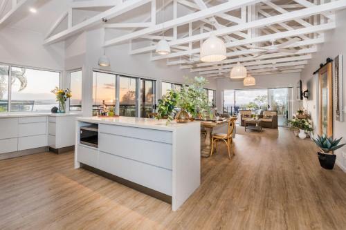 a kitchen and dining room with white cabinets and a table at Slipaway 1770 in Seventeen Seventy