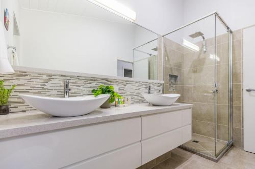a bathroom with two sinks and a glass shower at Slipaway 1770 in Seventeen Seventy