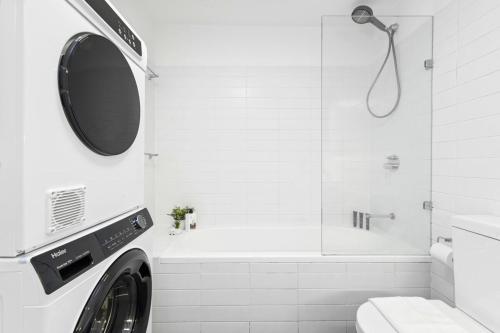 y baño con ducha y lavadora. en Cozy House near Darling Harbor, en Sídney