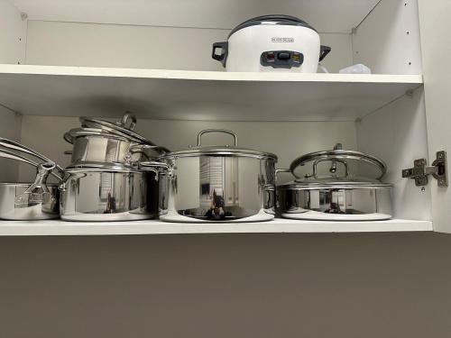 a bunch of pots and pans on a shelf at 4 Guests, 2 bedrooms, 2 queen beds basement apartment in Ajax in Ajax