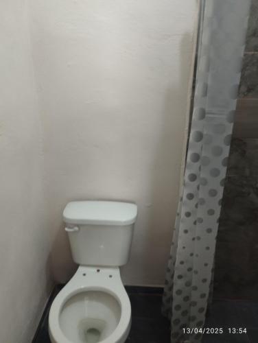 ein Badezimmer mit weißer Toilette und Dusche in der Unterkunft Depa in Mazatlán