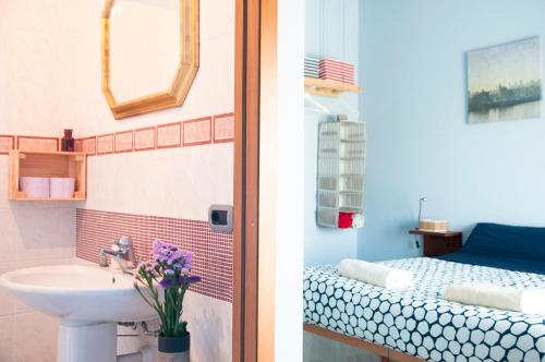 2 immagini di un bagno con lavandino e di una camera da letto di Blueberry Rooms a La Morra