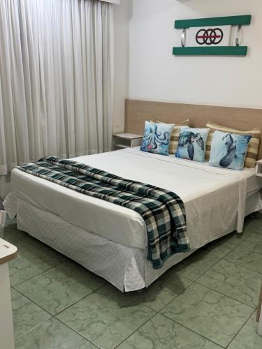 a bedroom with a large bed with blue pillows at Flats Linda Vista Para o Mar in Macaé