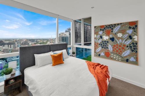 a bedroom with a white bed and a large window at Nook Melbourne Apartments : Jane Bell Lane - Melbourne CBD in Melbourne