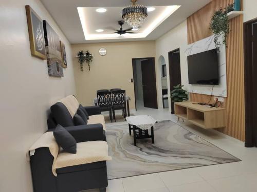 a living room with a couch and a tv at Ana Homestay in Seri Manjung