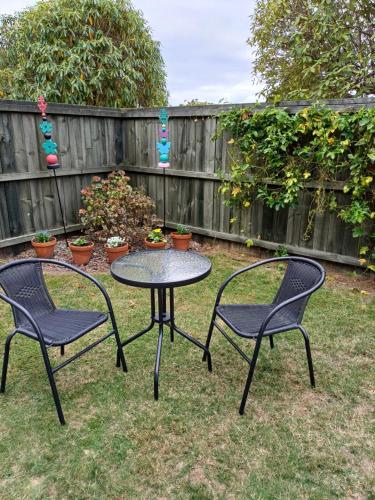 two chairs and a table in a yard at Rotorua Studio in Rotorua