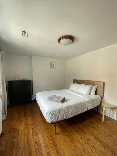 a bedroom with a large white bed and wooden floors at The Ambassador in Ottawa