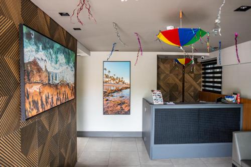 a room with a wall with paintings on it at Easy Porto Hotel in Porto De Galinhas