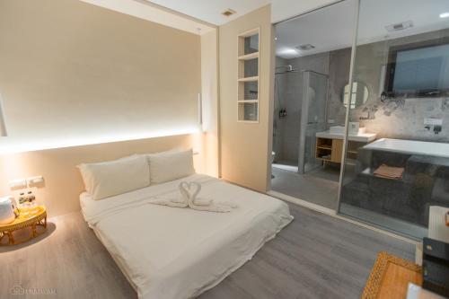 a bedroom with a white bed and a bathroom at Happiness . danshui in Tamsui